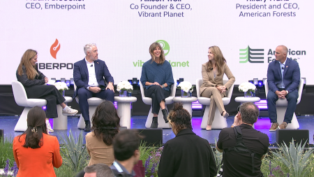 Five people are siting on a stage and having a conversation