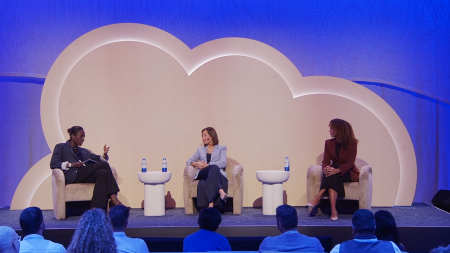 A wide shot of three seated women on stage