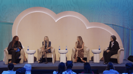 Four panelists smiling and sitting in chairs
