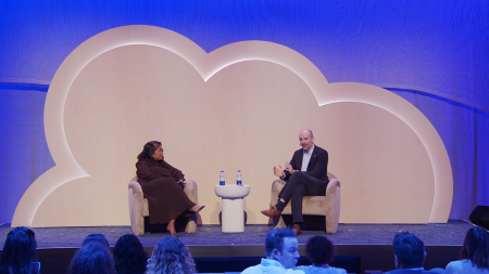 There are two people on stage sitting in chairs and having a conversation