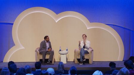 Two speakers sit on stage