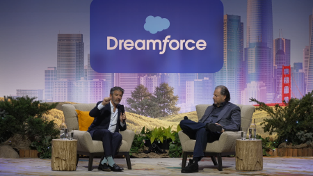 Two speakers seated on stage